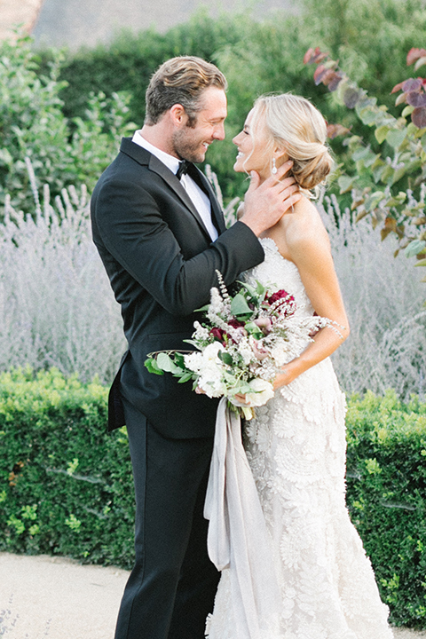 Santa-barbara-outdoor-wedding-at-kestrel-park-bride-and-groom-hugging-with-bouquet