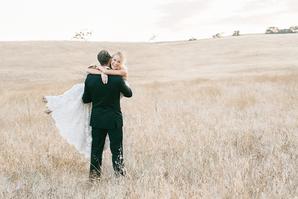 Santa-barbara-outdoor-wedding-at-kestrel-park-bride-and-groom-standing-holding-bride-smiling