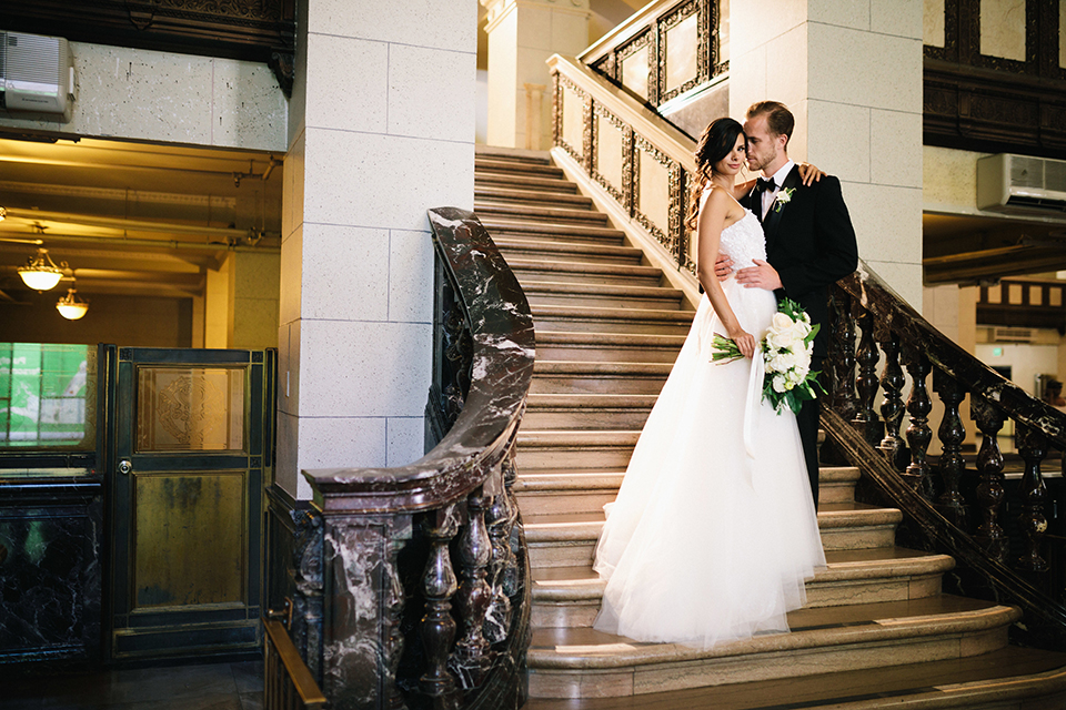 Los-angeles-wedding-at-the-majestic-bride-and-groom-standing-on-stairs-hugging-smiling