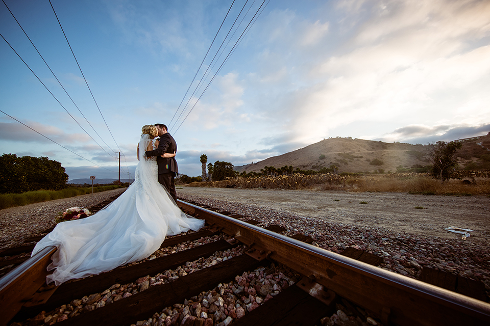 Orange-county-wedding-at-the-hamilton-oaks-winery-bride-and-groom-standing-hugging-far-away-and-kissing