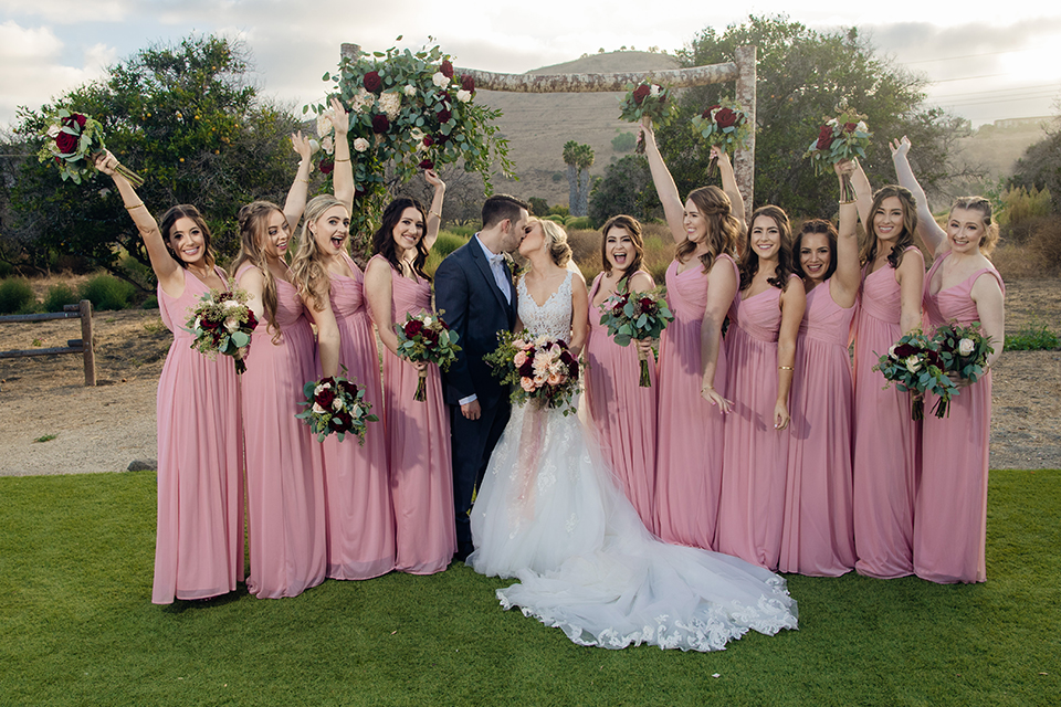 Orange-county-wedding-at-the-hamilton-oaks-winery-bride-and-groom-with-bridesmaids-kissing
