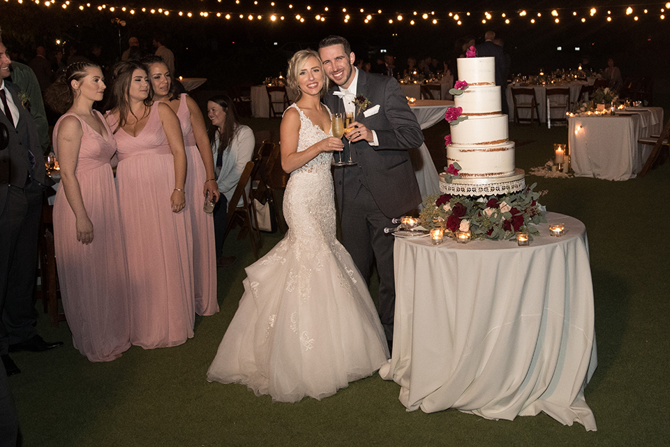 Orange-county-wedding-at-the-hamilton-oaks-winery-reception-bride-and-groom-cutting-cake-holding-drinks