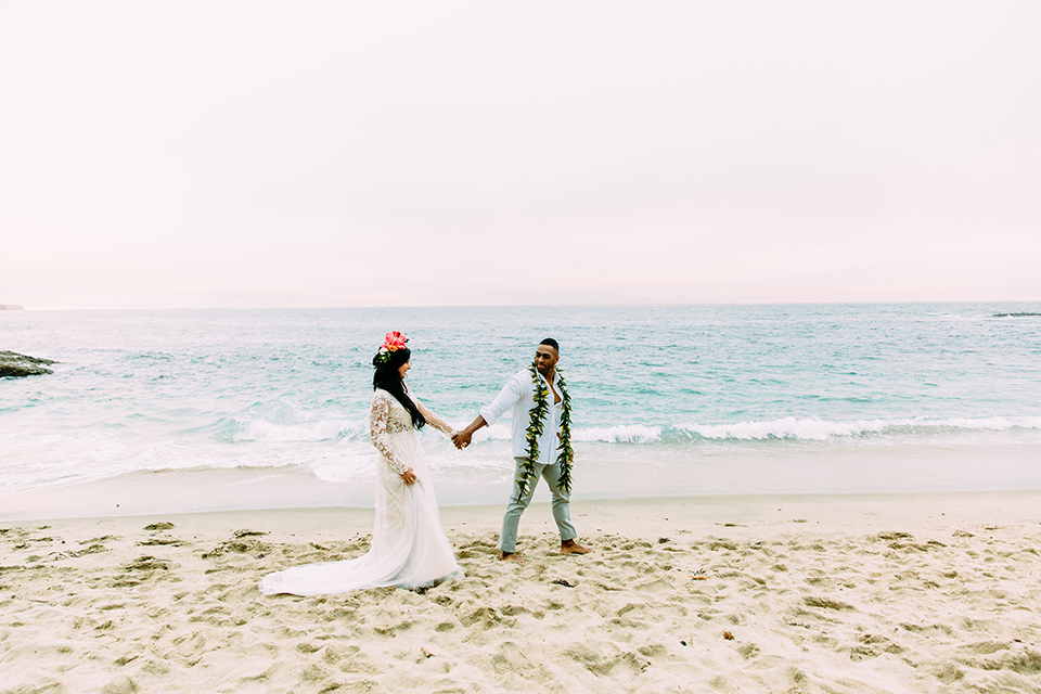 Orange-county-beach-wedding-in-dana-point-bride-and-groom-standing-holding-hands-walking