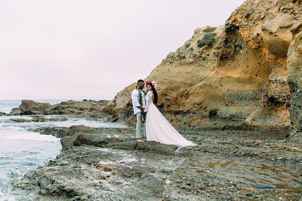 Orange-county-beach-wedding-in-dana-point-bride-and-groom-standing-on-rocks-hugging