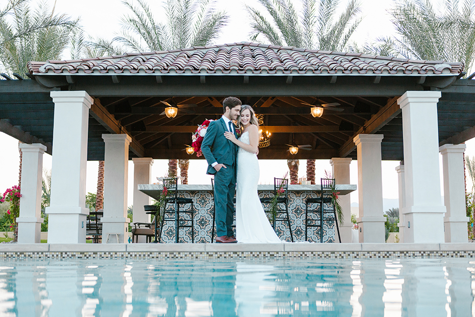 Palm-springs-wedding-shoot-at-old-polo-estate-bride-and-groom-standing-by-bar-smiling