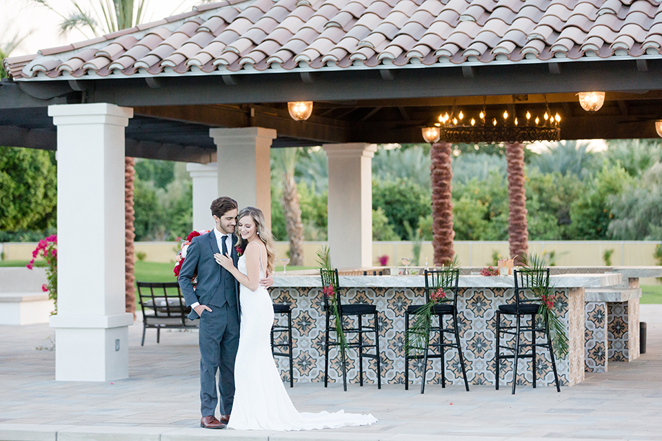 Palm-springs-wedding-shoot-at-old-polo-estate-bride-and-groom-standing-by-bar