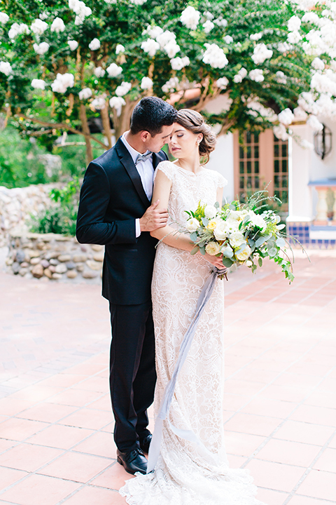 Rancho-las-lomas-outdoor-wedding-bride-and-groom-hugging-holding-bouquet