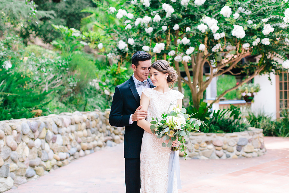 Rancho-las-lomas-outdoor-wedding-bride-and-groom-hugging-with-bouquet