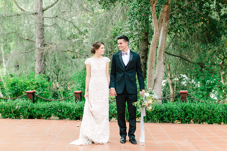 Rancho-las-lomas-outdoor-wedding-bride-and-groom-standing-holding-hands-and-bouquet