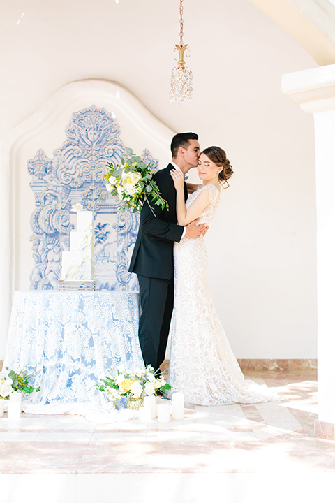 Rancho-las-lomas-outdoor-wedding-bride-and-groom-standing-hugging-by-cake