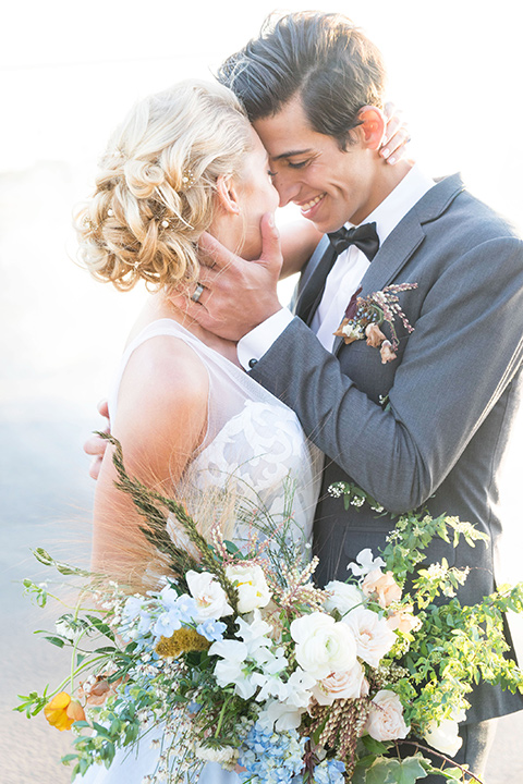 hangar-21-bride-and-groom-close-up-outside-bride-wearing-a-blue-dress-with-lace-details-on-the-bodice-and-flowing-light-blue-material-for-the-skirt-grooom-in-a-charcoal-tuxedo-with-a-matching-charcoal-tie