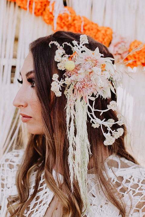 hey-babe-ranch-close-up-on-bridal-headpeice-bride-in-a-bohemian-gown-with-lace-and-fringe-detailing-and-hair-in-a-loose-wave-groom-in-a-burgundy-tuxedo-with-black-satin-truim-and-his-tie-undone-for-a-relaxed-look