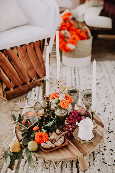 hey-babe-ranch-close-up-on-decor-bride-in-a-bohemian-gown-with-lace-and-fringe-detailing-and-hair-in-a-loose-wave-groom-in-a-burgundy-tuxedo-with-black-satin-truim-and-his-tie-undone-for-a-relaxed-look