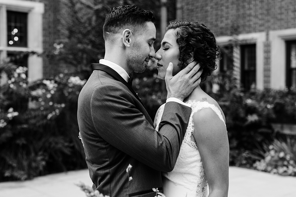 The-Mansion-at-Natirar-bride-and-groom-about-to-kiss-black-and-white-photo-bride-in-a-lace-fitted-dress-with-a-high-neckline-and-hair-up-groom-in-a-grey-tuxedo-with-black-trim-and-a-black-bowtie