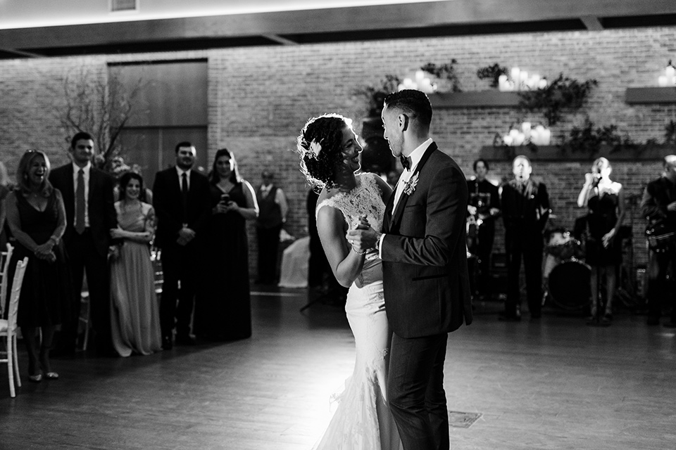 The-Mansion-at-Natirar-couple-first-dance-dress-with-a-high-neckline-and-hair-up-groom-in-a-grey-tuxedo-with-black-trim-and-a-black-bowtie