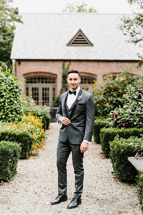 The-Mansion-at-Natirar-groom-standing-hands-in-pockets-groom-in-a-grey-tuxedo-with-black-trim-and-a-black-bowtie