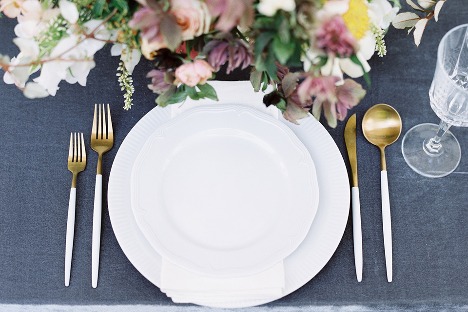 Taylor-Grady-House-shoot-tablewear-set-up-dusty-blue-velvet-linnen-with-simple-white-andmuted-gold-tablewear-with-muted-toned-florals-to-compliment-the-other-wedding-decor