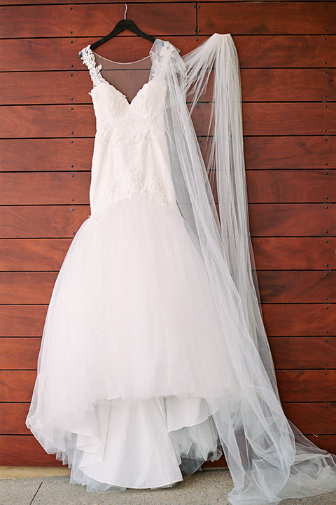 callaway-winery-shoot-bridal-gown-hanging-white-bridal-gown-with-straps-and-ace-detailing-hanging-by-a-brick-wall
