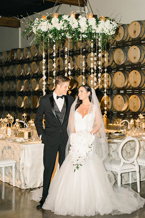 callaway-winery-shoot-bride-and-groom-in-the-reception-space-bride-wearing-a-fitted-dress-with-straps-and-tulle-and-lace-detailing-while-the-groom-wore-a-traditional-black-tuxedo-with a-black-bowtie