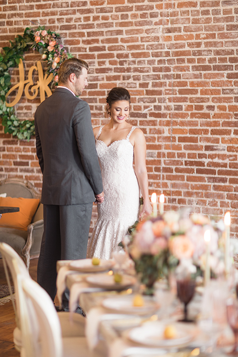 Orange-county-whimsical-wedding-at-franciscan-gardens-bride-and-groom-standing-by-table