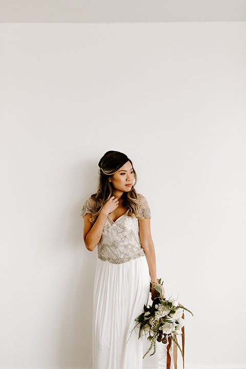 huntington-bay-club-shoot-bride-alone-looking-to-the-side-bride-wearing-a-flowing-dress-with-a-beaded-bodice-and-sleeves