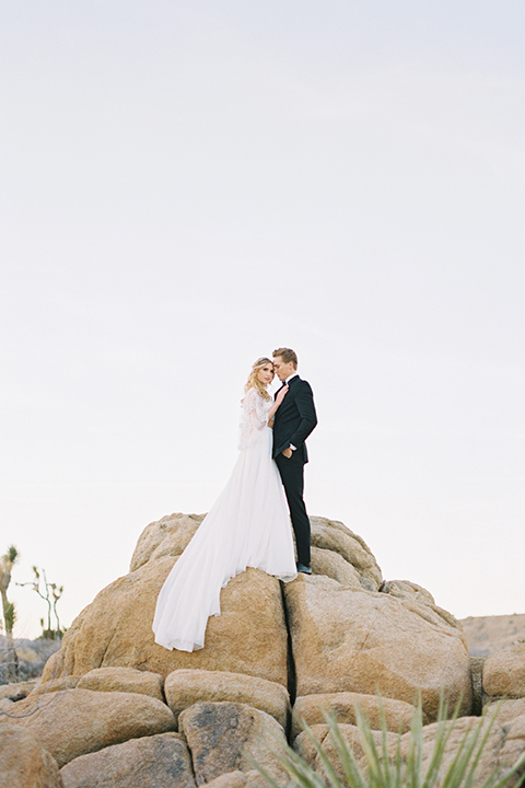 Joshua-tree-wedding-shoot-at-the-ruin-venue-bride-and-groom-standing-on-rocks