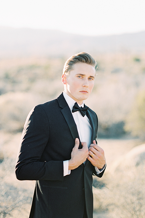 Joshua-tree-wedding-shoot-at-the-ruin-venue-groom-black-tuxedo-holding-coat-close-up