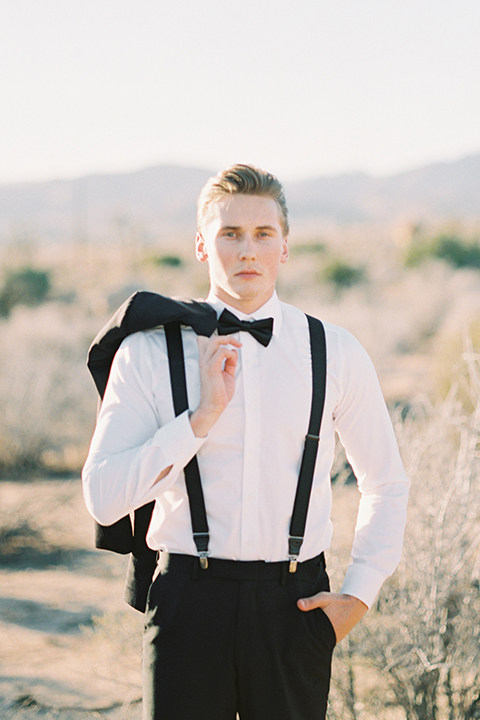 Joshua-tree-wedding-shoot-at-the-ruin-venue-groom-black-tuxedo-holding-coat-over-shoulders