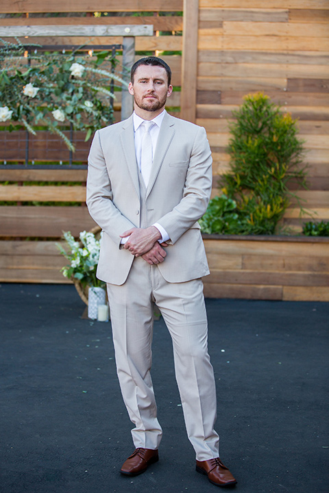 Lot-8-groom-standing-hands-in-front-of-succulent-wall-with-hands-crossed-in-front-of-him-further-shot