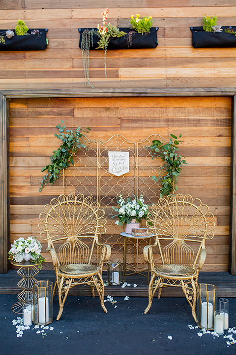 lot-8-chairs-wooden-boho-style-chairs-with-rounded-almost-wicker-like-top-in-a-carmel-brown-color-with-greenery-and-white-candles-all-around-and-reclaimed-wood-wall