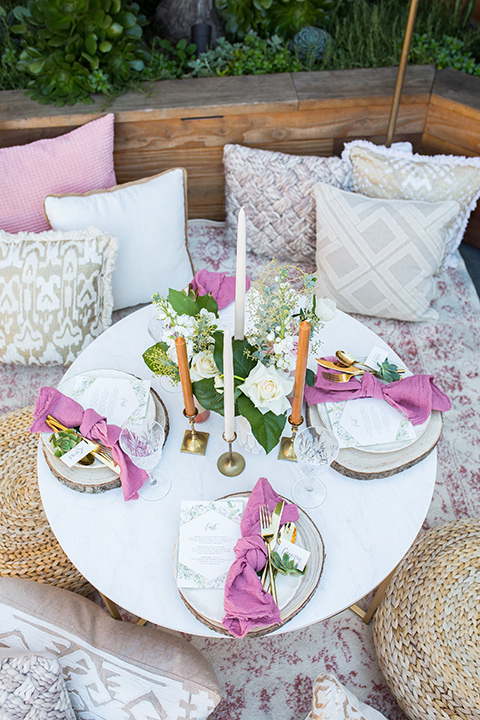 lot-8-table-set-up-with-pillows-rose-colored-napkins-with-white-table-and-white-plates-with-gold-accents