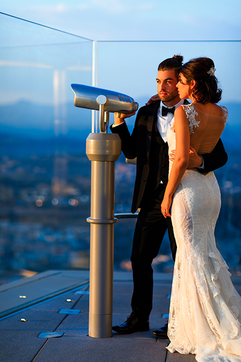 Downtown-los-angeles-wedding-shoot-at-oue-skyspace-bride-and-groom-standing-by-telescope