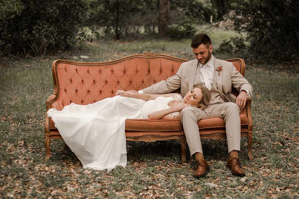 Texas-peaches-and-cream-wedding-shoot-at-carola-horse-ranch-bride-and-groom-sitting-on-couch-smiling