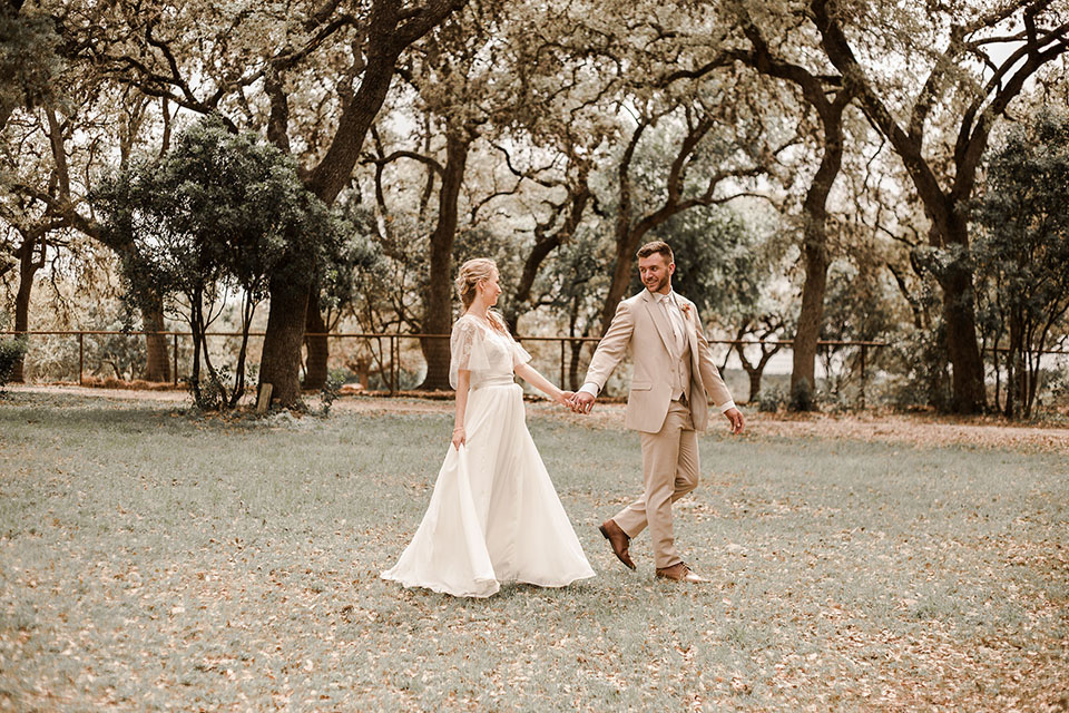 Texas-peaches-and-cream-wedding-shoot-at-carola-horse-ranch-bride-and-groom-standing-holding-hands