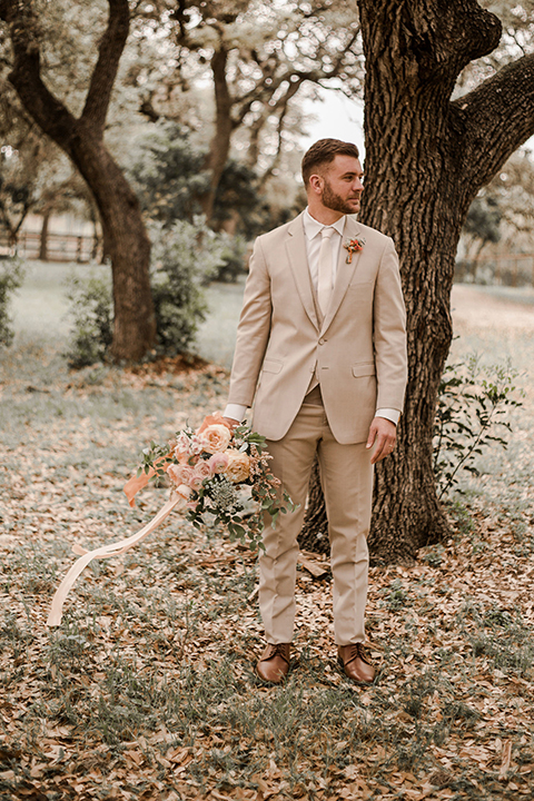 Texas-peaches-and-cream-wedding-shoot-at-carola-horse-ranch-groom-holding-bouquet