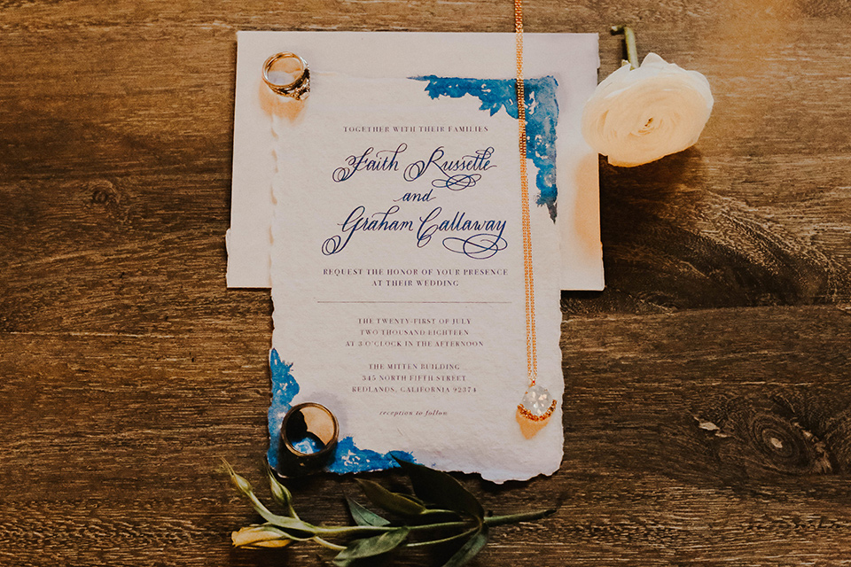 The-mitten-building-shoot-invitations-and-accessories-with-blue-accents-andgold-chains