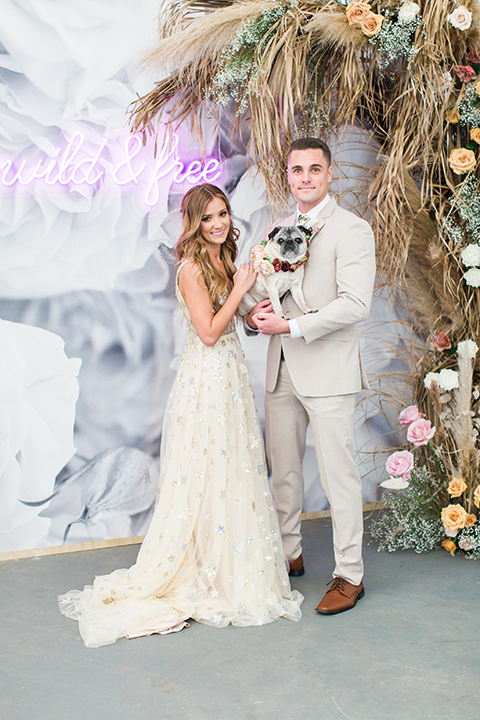 Los-angeles-garden-wedding-at-retreat-malibu-bride-and-groom-lounge-holding-dog-smiling