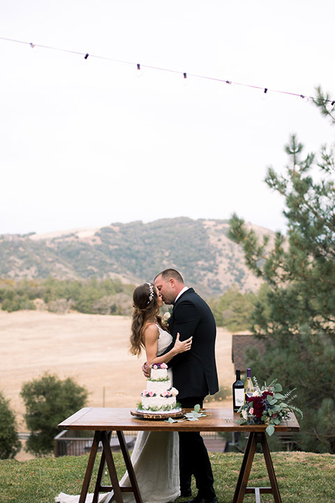 sacred-mountain-shoot-bride-and-groom-kissing-long-distance-shot-with-cake-table
