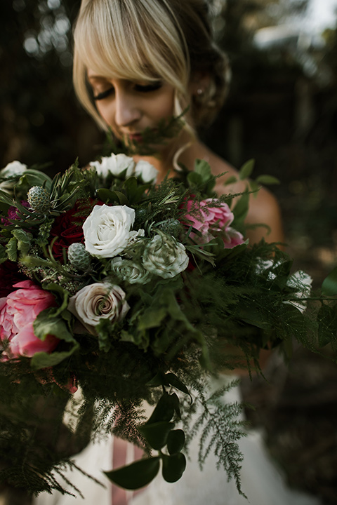 saddle-peak-bride-with-flowers-bride-in-an-off-the-shoulder-gown-with-lace-detailing-and-hair-up-in-a-bun