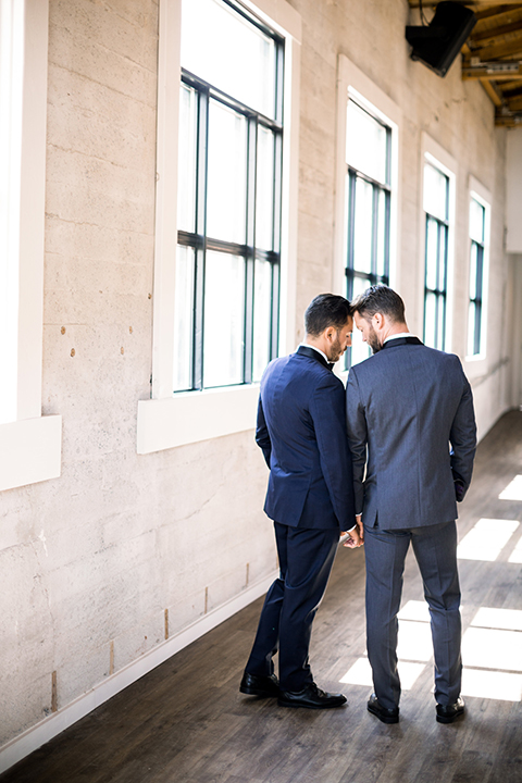 Same-sex-industrial-wedding-at-the-1912-groom-standing-and-holding-hands