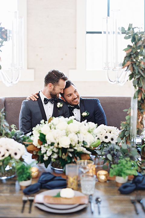 Same-sex-industrial-wedding-at-the-1912-grooms-sitting-at-table-hugging