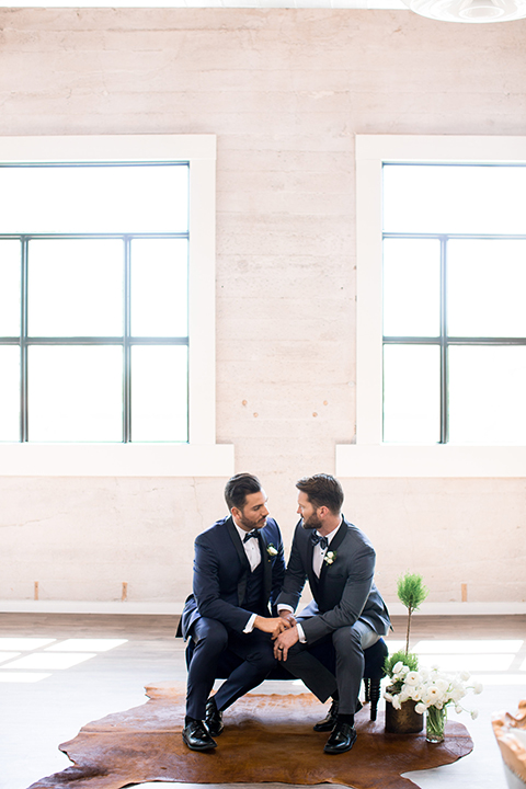 Same-sex-industrial-wedding-at-the-1912-grooms-sitting-holding-hands