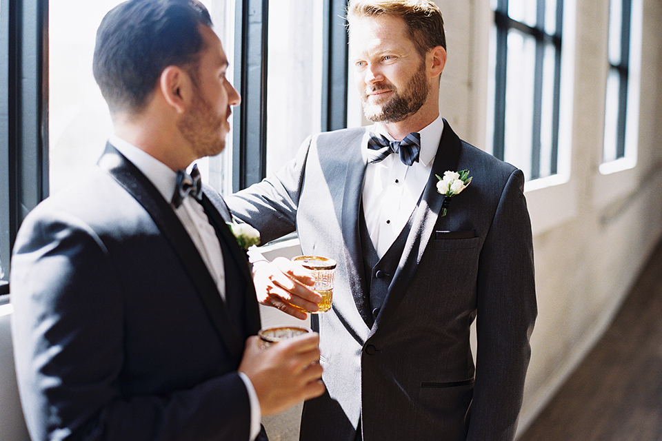 Same-sex-industrial-wedding-at-the-1912-grooms-standing-and-smiling-holding-drinks