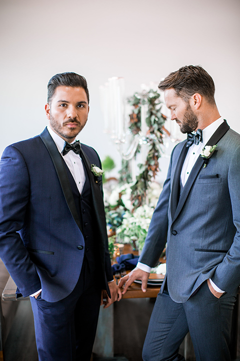 Same-sex-industrial-wedding-at-the-1912-grooms-standing-by-table-holding-hands