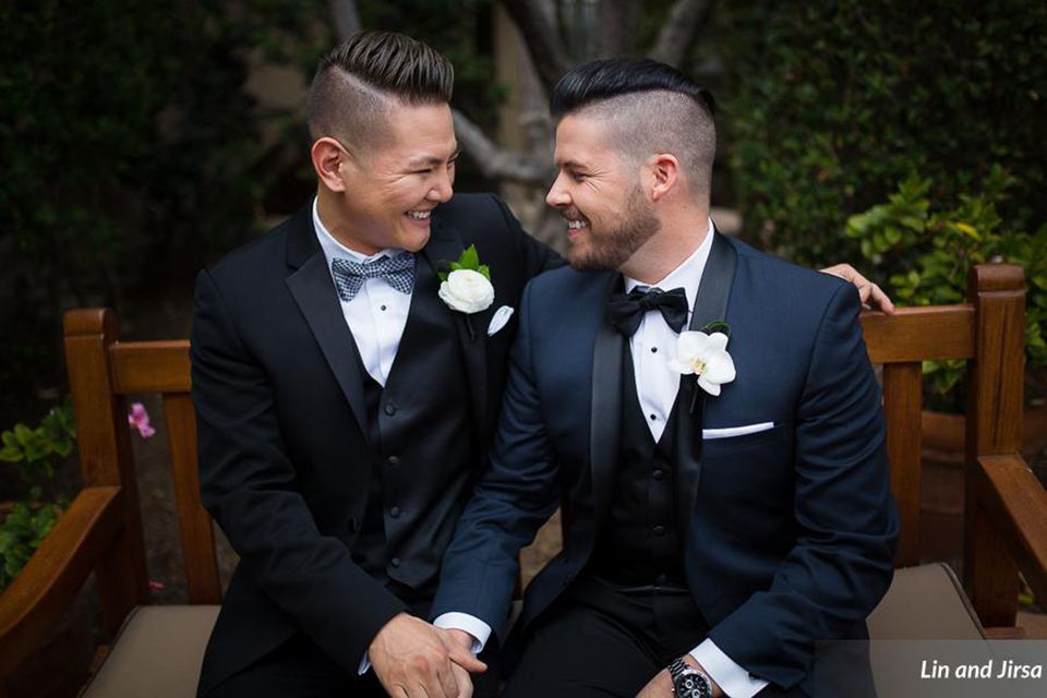 Laguna-beach-outdoor-wedding-same-sex-grooms-holding-hands-and-sitting