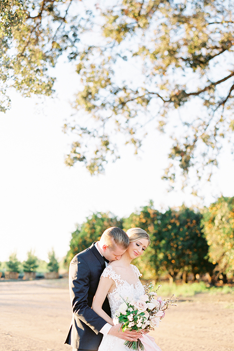 Southern-california-outdoor-wedding-at-the-orange-grove-bride-and-groom-hugging-holding-bouquet