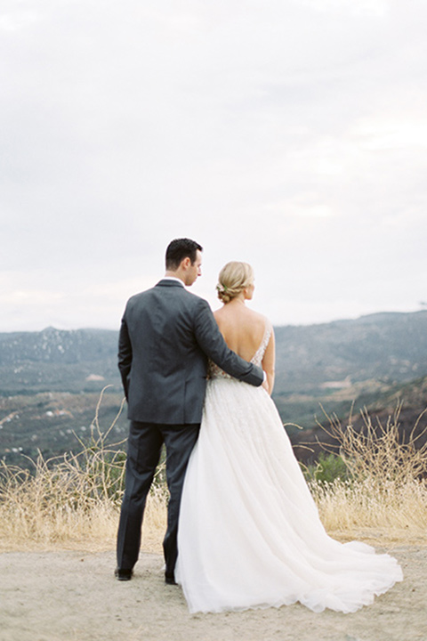 mountain-elopement-shoot-bride-and-groom-looking-out-to-the-view-bride-and-groom-dancing-final¬-Bride-in-a-tulle-ball-gown-with-an-illusion-bodice-and-lace-detailing-groom-at-sweetheart-table-groom-in-a-grey-tuxedo-with-a-black-bowtie