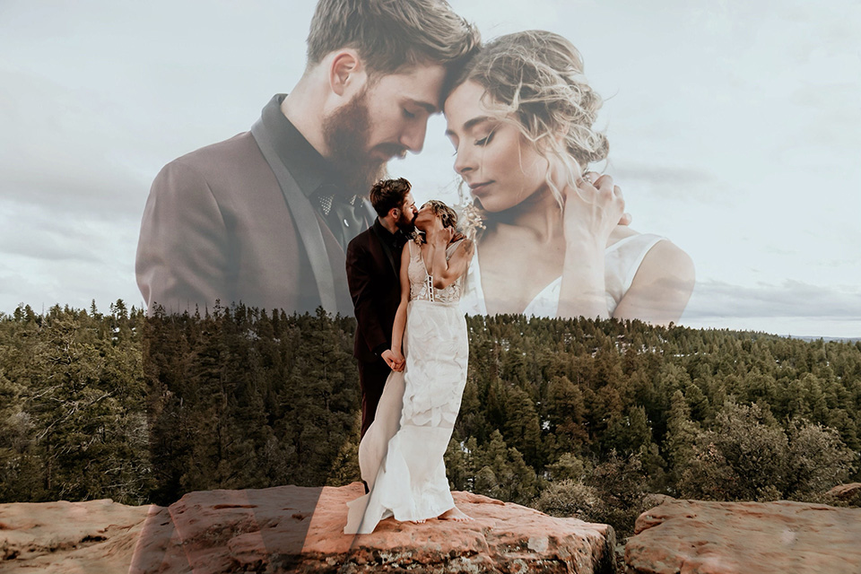 Arizona-Elopement-Shoot-bride-and-groom-touching-heads-on-mountain-the-bride-in-a-bohemian-white-gown-with-a-plunging-back-and-lace-detailing-the-groom-in-a-burgundy-shawl-lapel-tuxedo-with-a-black-shirt-and-bow-tie