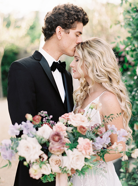 Artist-and-his-muse-shoot-bride-and-groom-close-the-bride-in-a-white-ballgown-with-an-illusion-neckline-and-deep-v-neckline-and-the-groom-in-a-black-tuxedo-with-a-black-bow-tie