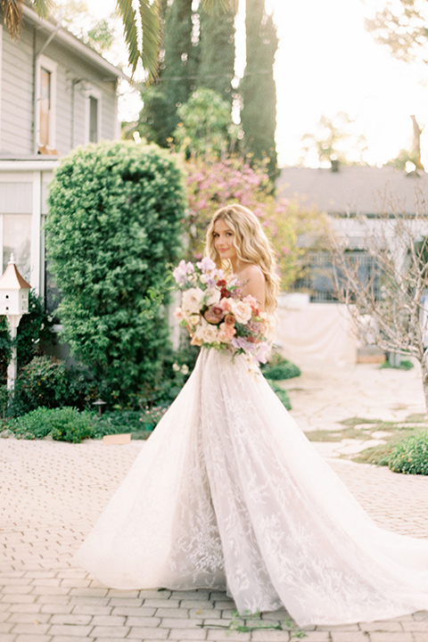 Artist-and-his-muse-shoot-bride-standing-in-a-white-ballgown-with-an-illusion-neckline-and-deep-v-neckline